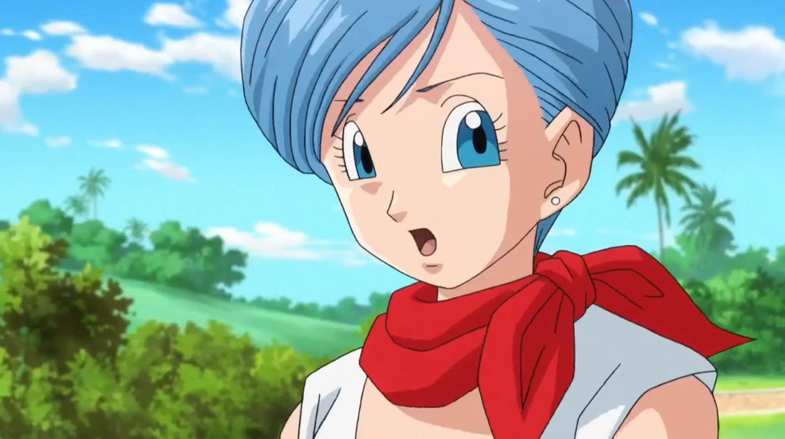 Bulma en gros plan, cheveux bleus courts et foulard rouge noué au cou, l'air étonné devant un paysage de palmiers sous un ciel bleu
