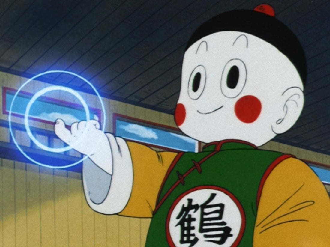 A smiling Chiaotzu in a green tunic emblazoned with the Crane kanji, holding out his hand as blue rings of telekinesis radiate from it