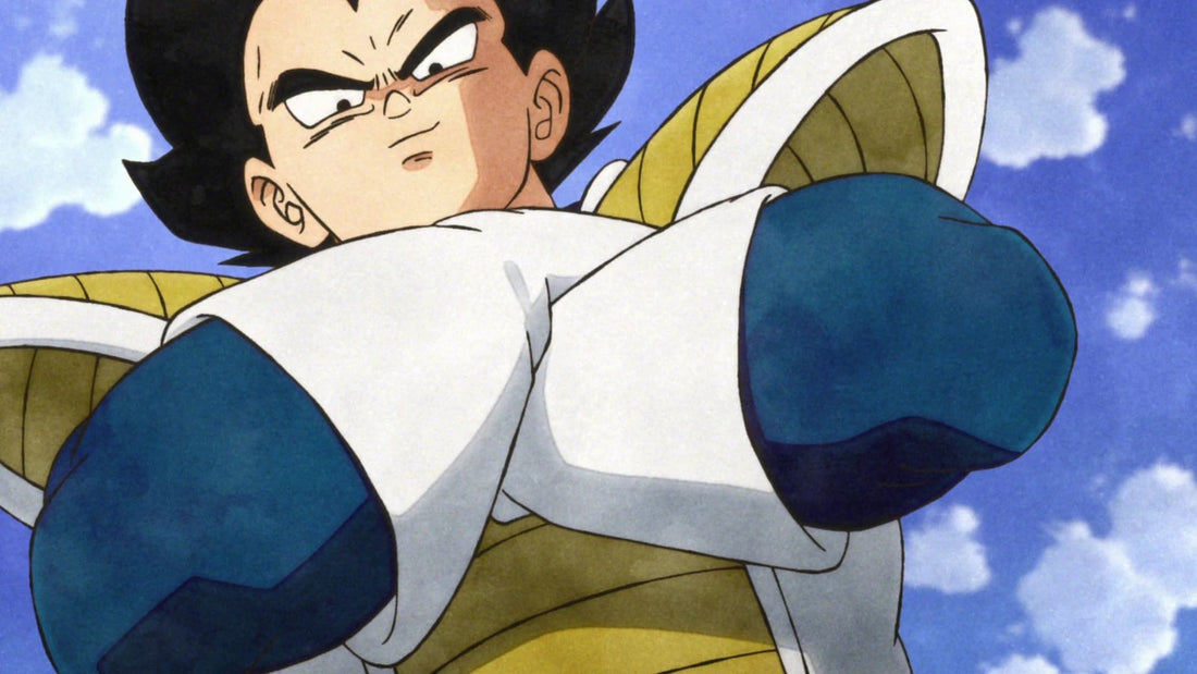 Vegeta, arms crossed in his white Saiyan armor with yellow shoulder pads, stares down at the scene, seen from a low angle against a cloudy blue sky.